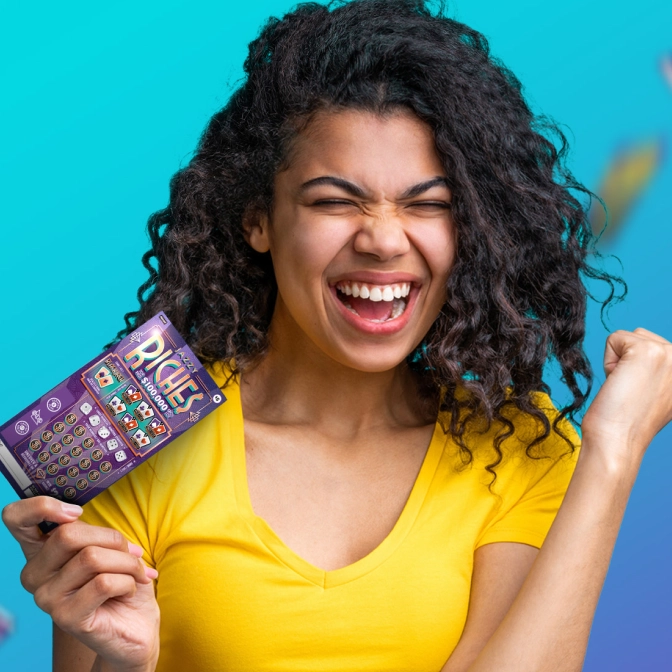 An excited woman in a yellow top celebrates with eyes shut and fist pumped, holding a purple scratch-off lottery ticket against a teal background.